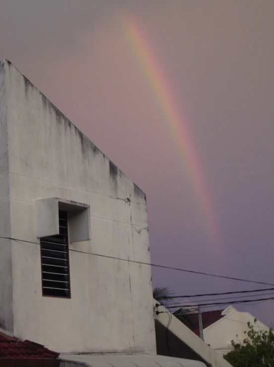 a rainbow over an apartment building with two open windows