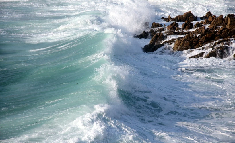 the ocean waves crashing on rocks are white