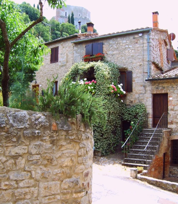 a stone building with many plants on the side of it