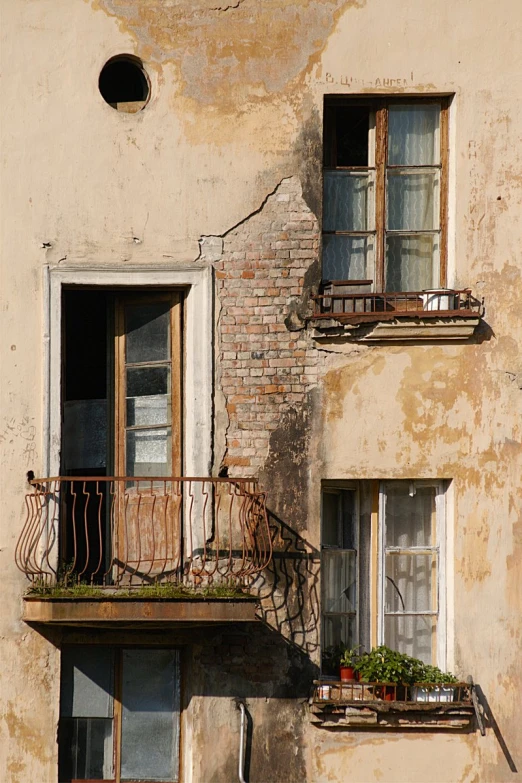 an old building with two balconies and balcony with plants growing out of them