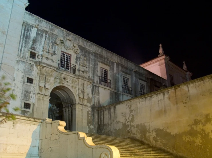 the old building with large arched doors is lit up