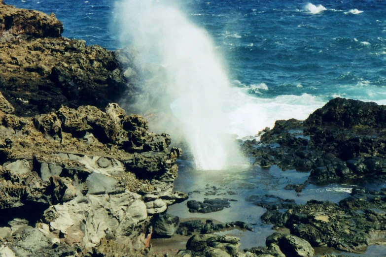 a closeup of the water and rocks by the beach