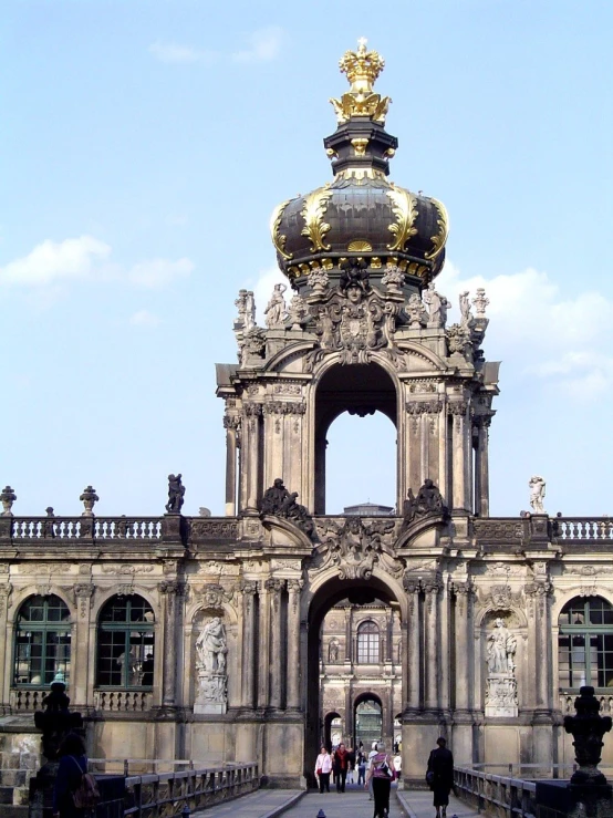 several people walk on the walkway near a structure