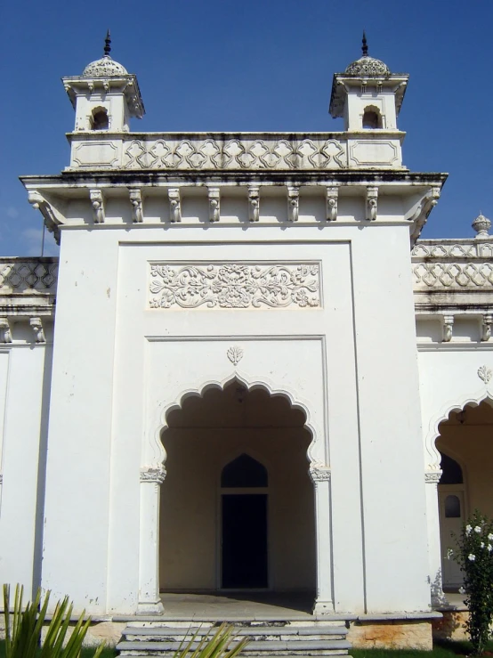 a white building with two doors and two windows