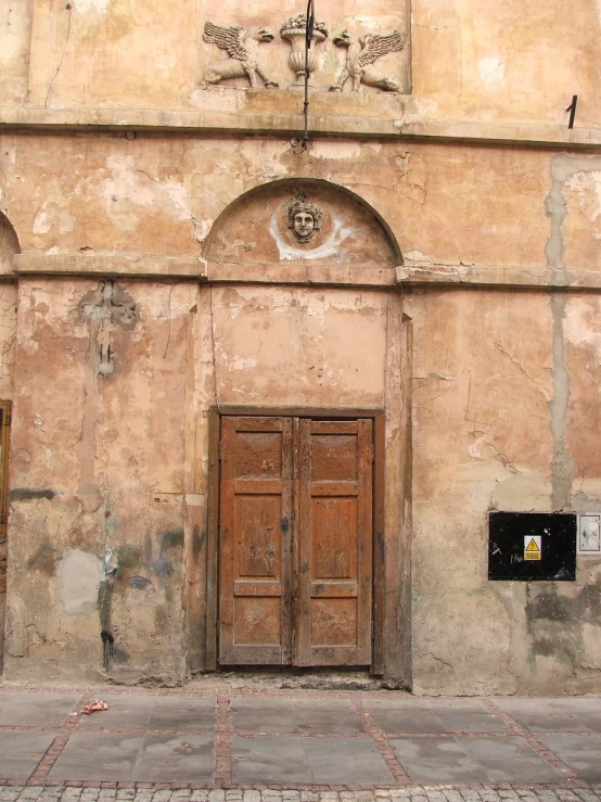 the exterior view of an old building with large wood doors