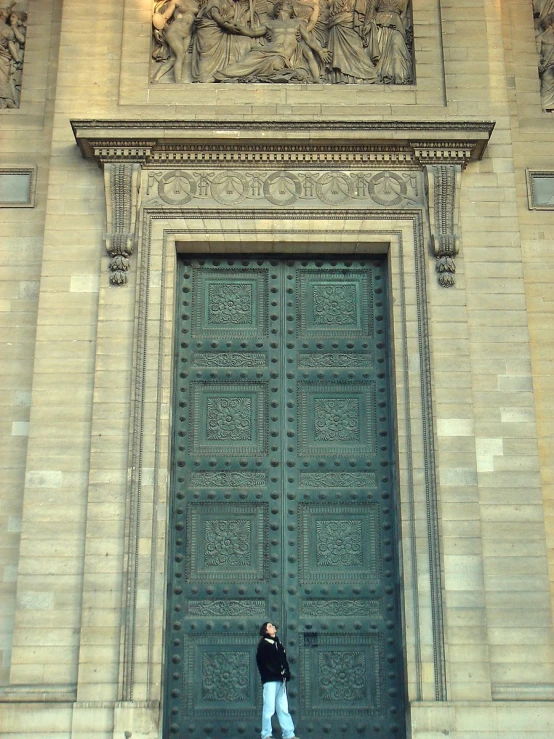 a person standing in front of a large green door