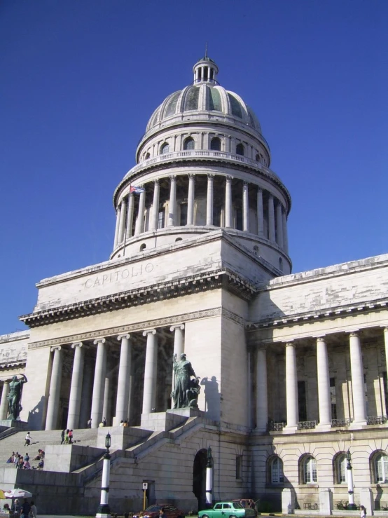 an ornate domed building has statues and columns