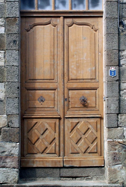 a stone wall with a wood door and windows