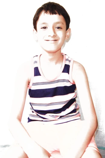 a boy in shorts and a tank top smiling