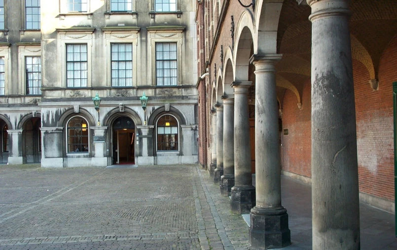 two rowed pillars with stone floors and large building behind