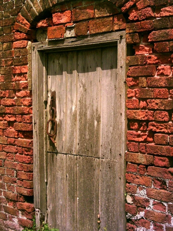 an old brick building has a wooden door