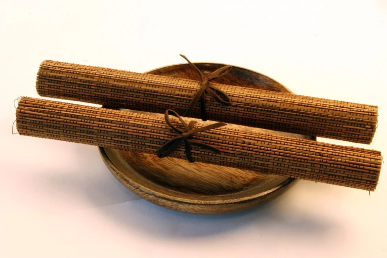 two sticks sitting in a bowl tied up