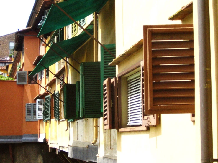 a window with shutters opened and green blinds