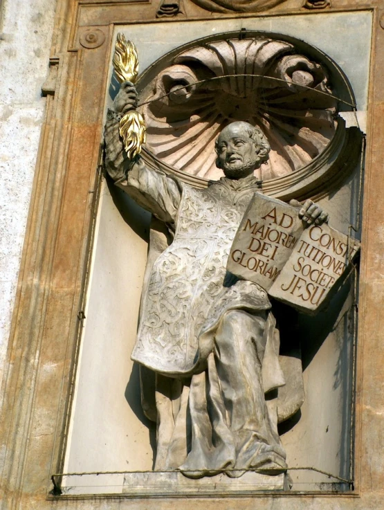 a sculpture of a man holding a feather next to a sign