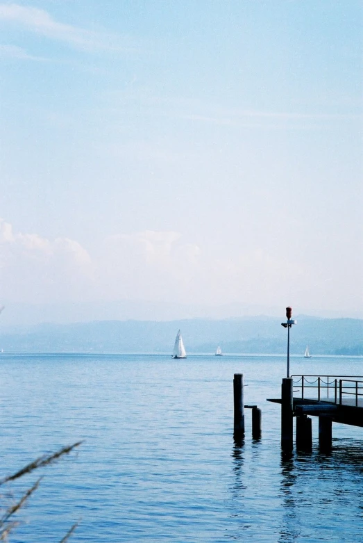 a boat is sailing down the river near the pier