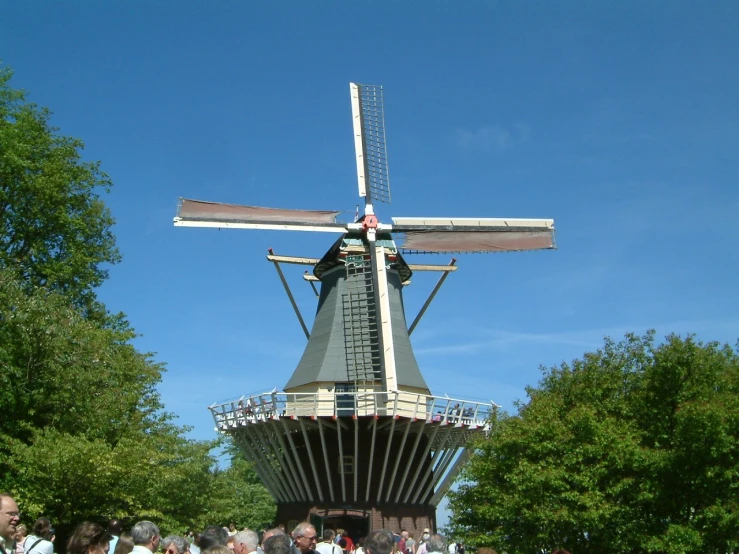 a very tall white windmill on a sunny day