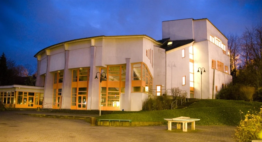 a large white building with some windows and a bench