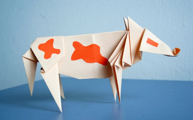 a white cow cut out with red shapes