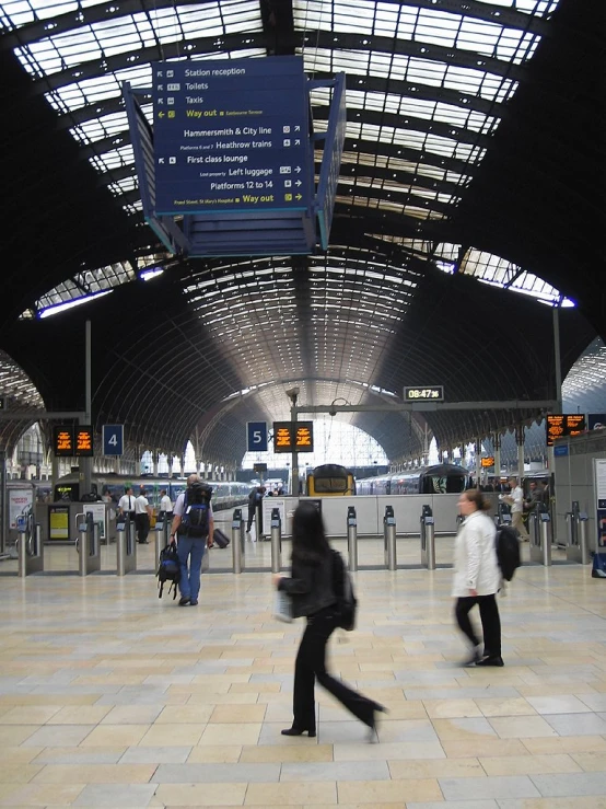 people in a station, with signs overhead