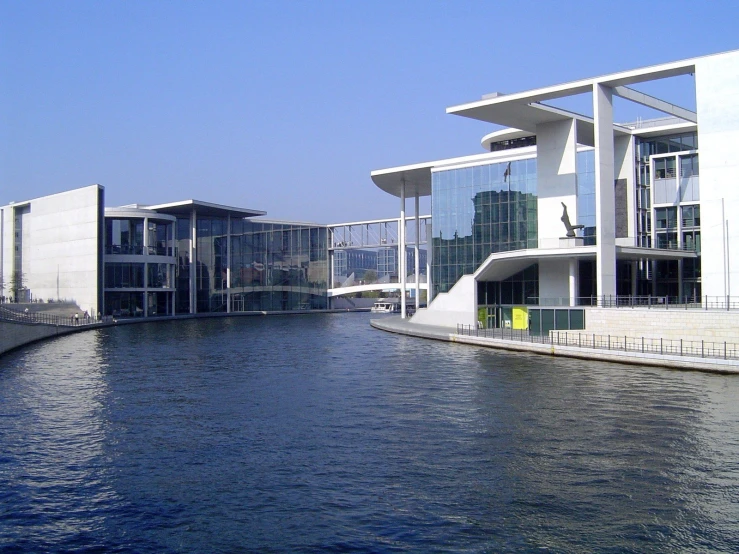 a building on the water near a bridge