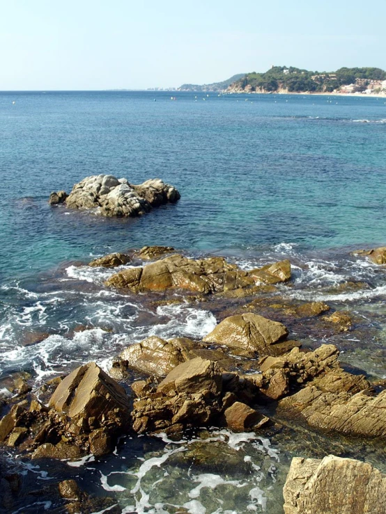 a view of a rocky beach and sea with waves