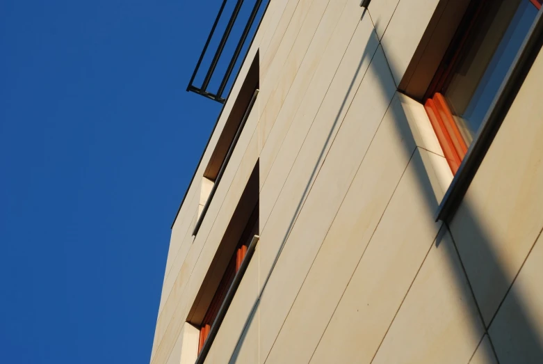 an apartment building with multiple windows under a blue sky