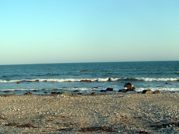 an empty sandy beach next to the ocean