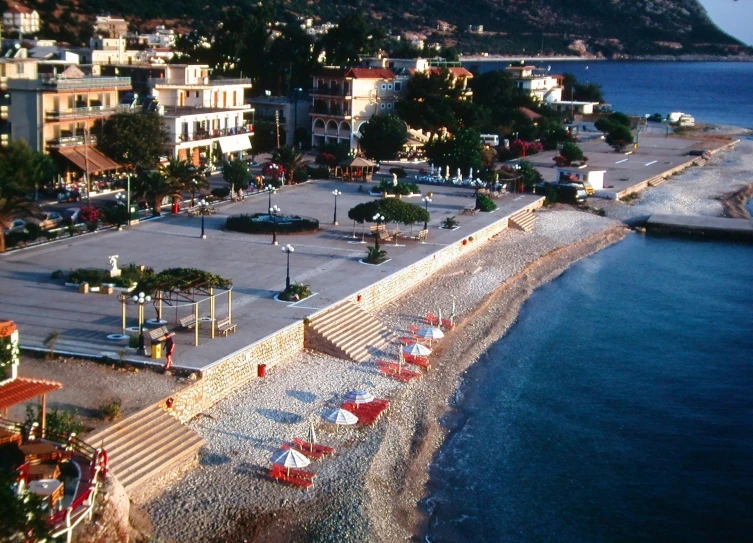 a beach with many beach chairs and umbrellas