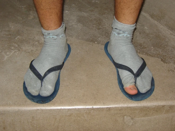 the person is wearing sandals and socks on a step