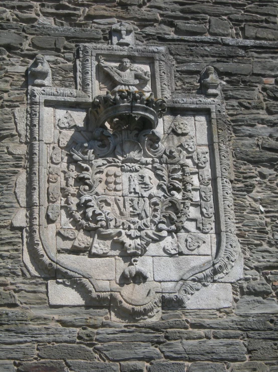 the coat of arms on this stone building are decorated with a crown