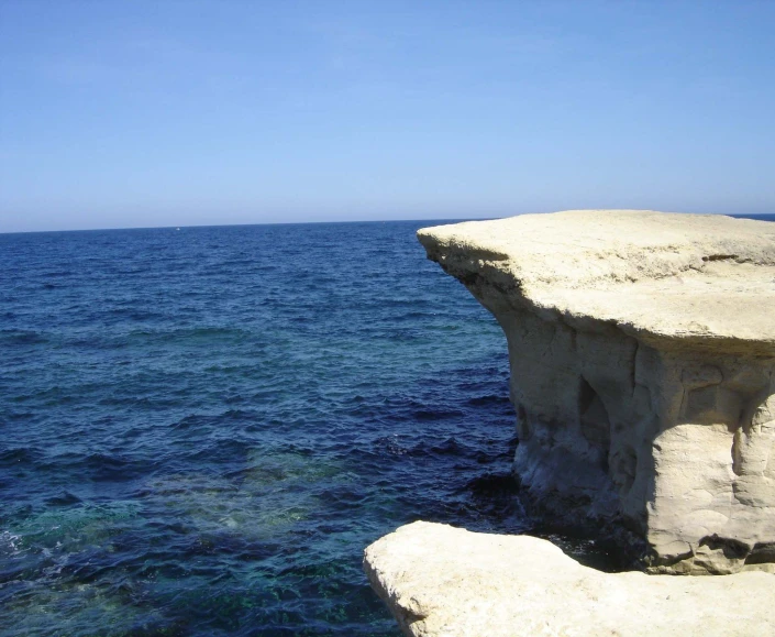 blue water with white rocks and a sky background