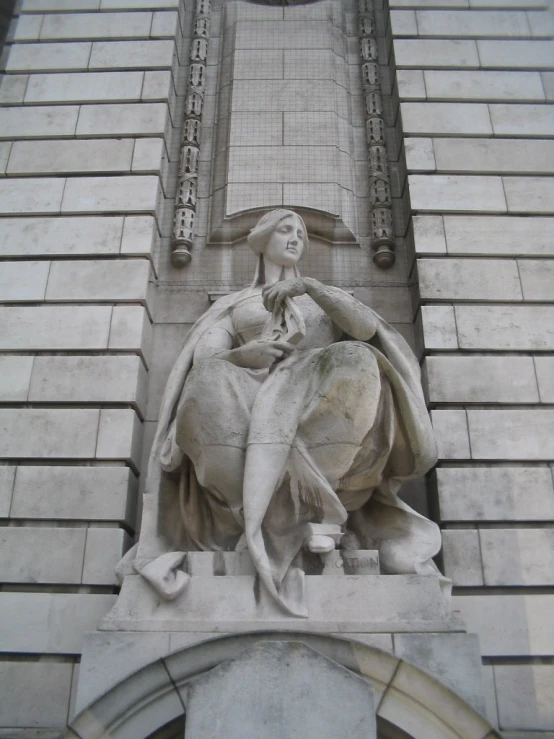 the woman is sitting on the horse statue