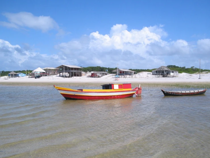 two boats are sitting in the water at the beach