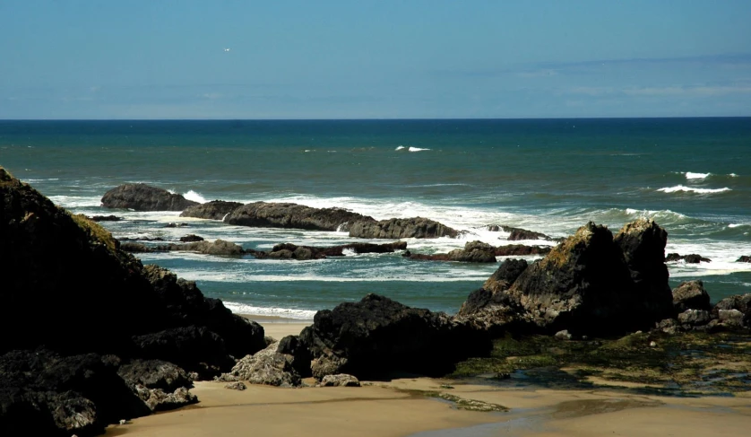 view over a rocky shore from the beach