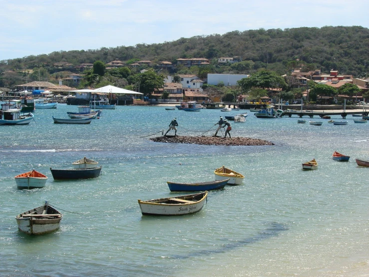 there are small boats floating on the blue water