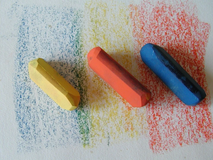 crayons sitting on the ground with colored crayons in them