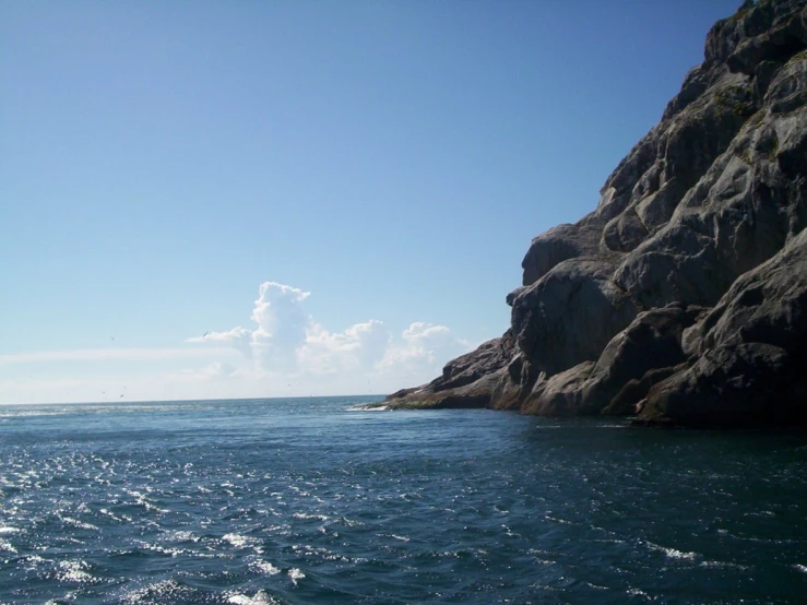 some rocks water and a bright blue sky