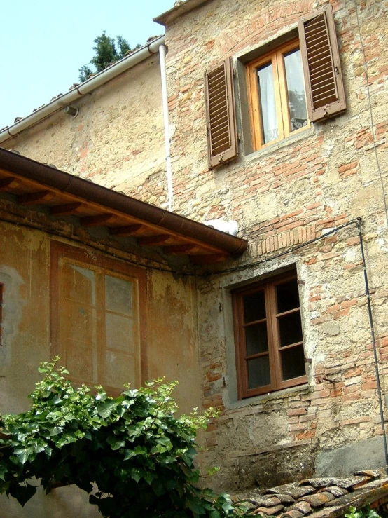 a house with the open windows and a few vines