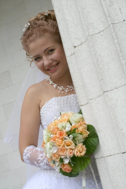 young woman in wedding dress holding a bridal bouquet