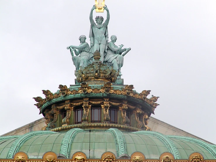 the statue on top of the building has four statues