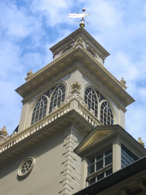 an ornate tower atop a building with a weather vein