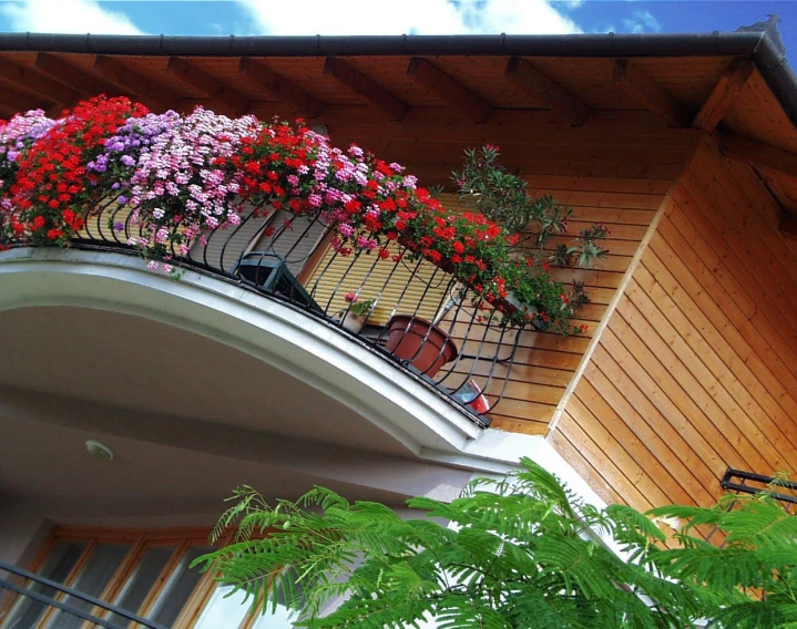 a balcony with pots of plants and chairs on the top