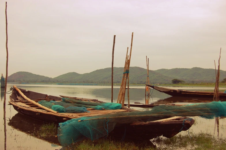 several boats sit in the water with ropes around them