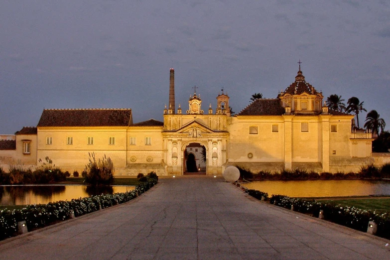 a large yellow castle that has trees on both sides