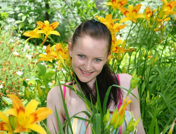 a  sitting in a flower bed surrounded by tall grass