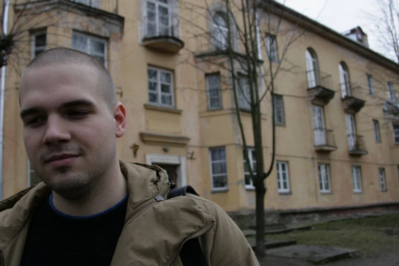 a man posing for a picture in front of an old building