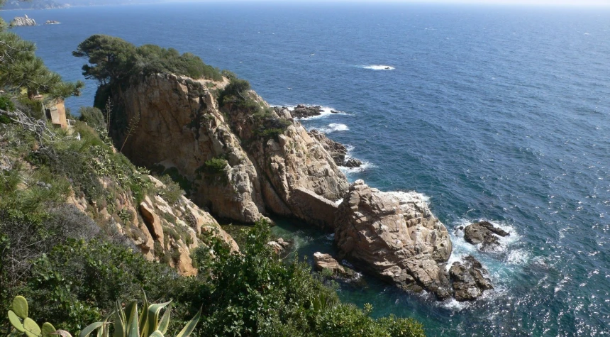 large rock formations rise up from the water