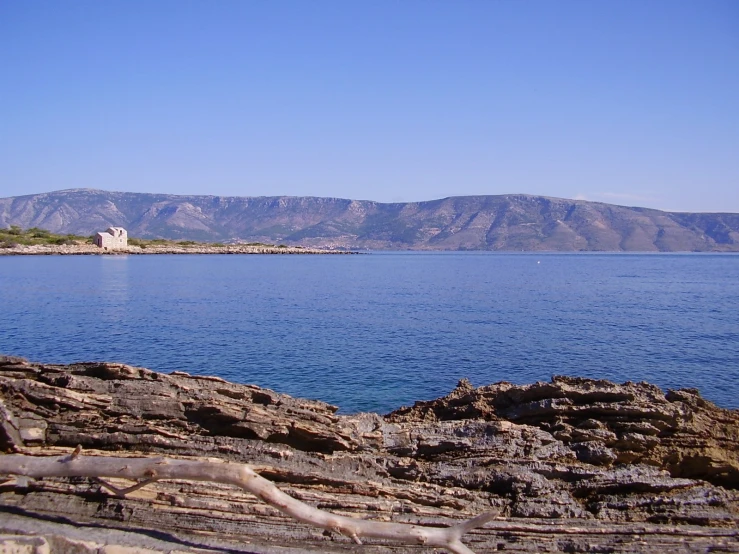 a rock formation in the foreground and a body of water to the far side