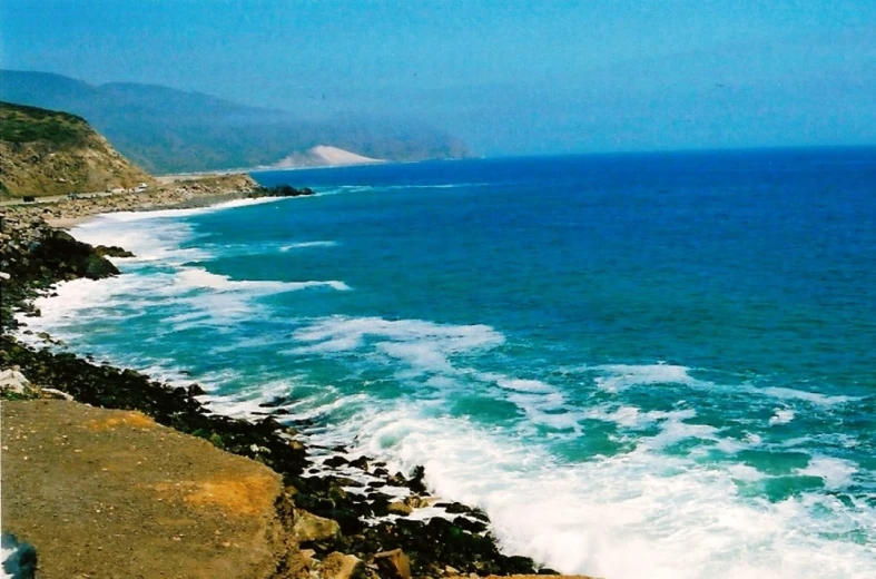 waves roll in and over the rugged coast