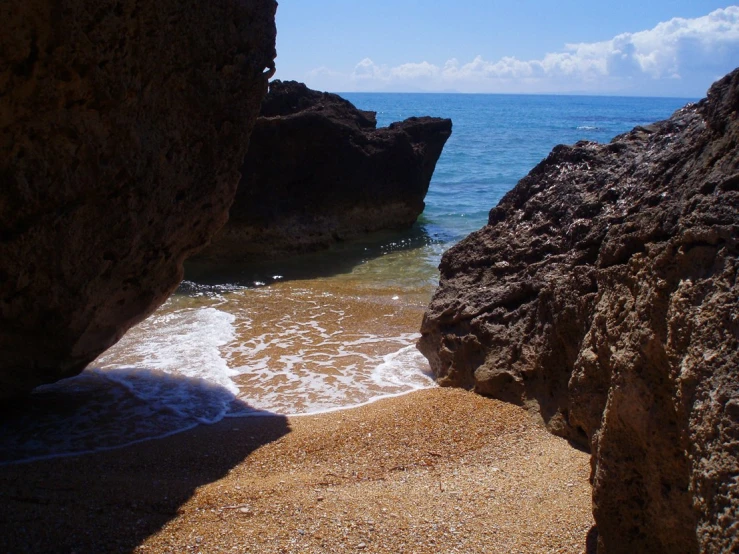 the beach has an open cave between the rocks